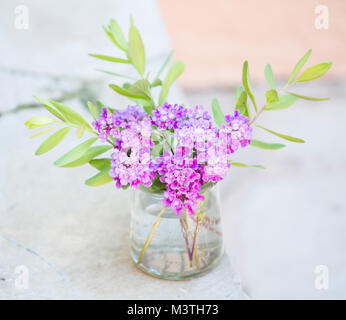 Ein Bündel von Country Garden Blumen in einem Glas Marmeladenglas angeordnet. Stockfoto