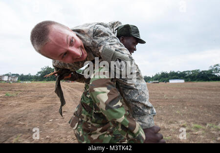 Ein Gabunischen der Bundeswehr Soldat trägt eine US-Armee SPC. Ridgely, ein infanterist mit der 3Rd Battalion, 7th Infantry Regiment, 2nd Brigade Combat Team, 3rd Infantry Division, während ein taktisches Unfallversicherung Care Kurs auf der diesjährigen zentralen Accord Übung in Libreville, Gabun am 17. Juni 2016. Us-Armee Afrika übung Zentrale Accord 2016 ist eine jährliche, kombiniert, gemeinsame militärische Übung, die zusammen bringt Partner Nationen zu Praxis und Kenntnisse in der Durchführung von friedenserhaltenden Maßnahmen zeigen. (DoD Nachrichten Foto durch TSgt Brian Kimball) 160617-F-QP 401-094 von DoD News Fotos Stockfoto