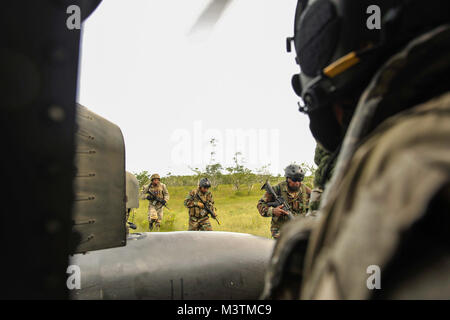 Mitglieder des Belize Special Assignment Group Board ein UH-60 Black Hawk auf das erste gemeinsame Aufgabe Force-Bravo's Battalion, 228Th Aviation Regiment, als Mannschaft Leiter schaut während der Ausbildung in der Belize District, 20. Juli 2016. Die BSAG und Belize Coast Guard durchgeführt, verschiedene Hubschrauber Operationen im Laufe der Woche von Juli 18. bis 22. Um die Möglichkeiten der belizischen Kräfte gegen die grenzüberschreitende organisierte Kriminalität in ihrem Land- und Seegrenzen Verhalten zu verbessern. (U.S. Air Force Foto: Staff Sgt. Siuta B. Ika) 160720-F-JB 386-179 durch ussouthcom Stockfoto