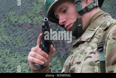 Grafenwöhr, Deutschland - Oberleutnant Liam Yeo, Experte Bereich Medizinische Abzeichen (EFMB) Kandidaten aus dem Vereinigten Königreich, löst ein 9-mm-Pistole Berretta während der Demonstration Teile der US-Army Europe EFMB Bewertung in Grafenwöhr, Deutschland am 23. März 2017. Etwa 215 Kandidaten aus der U.S. Army und zehn europäischen Partner Nationen nahmen an diesem alle zwei Jahre stattfindenden Bewertung in den Hoffnungen des Erzielens der begehrten US-Armee EFMB. (U.S. Air Force Foto von TSgt Brian Kimball) 170323-F-QP 401-015 von DoD News Fotos Stockfoto