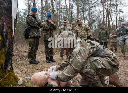 Grafenwöhr, Deutschland - Sehr geehrte Besucher aus der Bundeswehr Operative medizinische Unterstützung Befehl und 21 Theater Support Command beobachten ein Feld medizinische Demonstration während einer US-Armee Soldat bei der US-Armee Europa Experten Bereich Medizinische Abzeichen Bewertung in Grafenwöhr, Deutschland am 24. März 2017. Etwa 215 Kandidaten aus der US-Armee und zehn europäischen Partner Nationen nahmen an diesem alle zwei Jahre stattfindenden Bewertung in den Hoffnungen des Erzielens der begehrten US-Armee EFMB. (U.S. Air Force Foto von TSgt Brian Kimball) 170324-F-QP 401-025 von DoD News Fotos Stockfoto