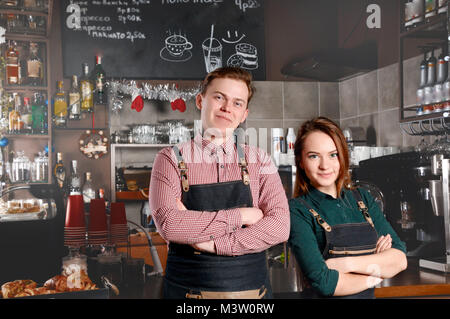 Paar barista Seite an Seite im Cafe. Schöner Mann und attraktive Frau macht Kaffee. Lebensmittel- und Getränkeindustrie Konzept Stockfoto