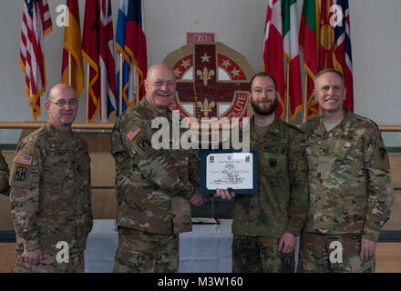 Grafenwöhr, Deutschland - Kapitän Marx Gunnar (Mitte rechts), eine US-Armee Experte Bereich Medizinische Abzeichen (EFMB) Empfänger mit dem Deutschen Militär, erhält eine Bescheinigung über den Abschluss von U.S. Army Colonel Brian Almquist (Mitte links), Commander 212th Combat Support Hospital, während einer US-Army Europe EFMB Bewertung in Grafenwöhr, Deutschland am 30. März 2017. Etwa 215 Kandidaten aus der US-Armee und zehn europäischen Partner Nationen nahmen an diesem alle zwei Jahre stattfindenden Bewertung in den Hoffnungen des Erzielens der begehrten US-Armee EFMB aber nur 64 erhalten hat, während der diesjährigen Auswertung. (U.S. Air Force Foto von TS Stockfoto