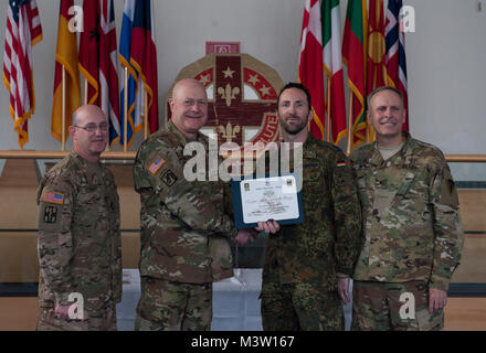 Grafenwöhr, Deutschland - Major Rene Schliebener (Mitte rechts), eine US-Armee Experte Bereich Medizinische Abzeichen (EFMB) Empfänger mit dem Deutschen Militär, erhält eine Bescheinigung über den Abschluss von U.S. Army Colonel Brian Almquist (Mitte links), Commander 212th Combat Support Hospital, während einer US-Army Europe EFMB Bewertung in Grafenwöhr, Deutschland am 30. März 2017. Etwa 215 Kandidaten aus der US-Armee und zehn europäischen Partner Nationen nahmen an diesem alle zwei Jahre stattfindenden Bewertung in den Hoffnungen des Erzielens der begehrten US-Armee EFMB aber nur 64 erhalten hat, während der diesjährigen Auswertung. (U.S. Air Force Foto von Stockfoto