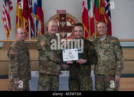 Grafenwöhr, Deutschland - Private First Class Noah Leon Wegmann (Mitte rechts), eine US-Armee Experte Bereich Medizinische Abzeichen (EFMB) Empfänger mit dem Deutschen Militär, erhält eine Bescheinigung über den Abschluss von U.S. Army Colonel Brian Almquist (Mitte links), Commander 212th Combat Support Hospital, während einer US-Army Europe EFMB Bewertung in Grafenwöhr, Deutschland am 30. März 2017. Etwa 215 Kandidaten aus der US-Armee und zehn europäischen Partner Nationen nahmen an diesem alle zwei Jahre stattfindenden Bewertung in den Hoffnungen des Erzielens der begehrten US-Armee EFMB aber nur 64 erhalten hat, während der diesjährigen Auswertung. (U.S. Luft Stockfoto