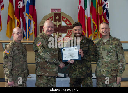 Grafenwöhr, Deutschland - Private 1. Klasse Alexander Beck (Mitte rechts), eine US-Armee Experte Bereich Medizinische Abzeichen (EFMB) Empfänger aus der Deutschen Bundeswehr, erhält eine Bescheinigung über den Abschluss von U.S. Army Colonel Brian Almquist (Mitte links), Commander 212th Combat Support Hospital während einer US-Army Europe EFMB Bewertung in Grafenwöhr, Deutschland am 30. März 2017. Etwa 215 Kandidaten aus der US-Armee und zehn europäischen Partner Nationen nahmen an diesem alle zwei Jahre stattfindenden Bewertung in den Hoffnungen des Erzielens der begehrten US-Armee EFMB aber nur 64 erhalten hat, während der diesjährigen Auswertung. (U.S. Luft für Stockfoto