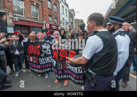 Die Polizei bittet die Klasse Krieg Frauen Todesschwadronen ihre Fahne weg von der Straße, die Sie blockieren aus Protest gegen einen Jack the Ripper touristische Attraktion am Kabel St. sind zu berücksichtigen Stockfoto