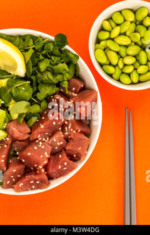 Im Hawaiianischen Stil Thunfisch und Avocado Sashimi Poke Futternapf auf rotem Hintergrund Stockfoto