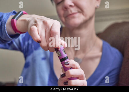 Weibchen mit e-Zigarette, vaping und neu befüllen Stockfoto