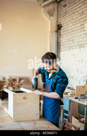 Tischler Bohrer ein Loch mit einer elektrischen Bohrmaschine Stockfoto