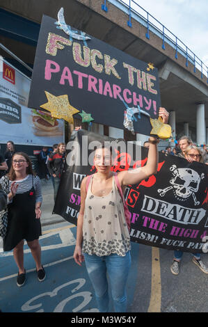 Leute am Protest gegen die Jack the Ripper Museum stehen in der Fahrbahn außerhalb des Museums mit der Klasse Krieg Frauen Todesschwadronen Banner und ein eingerichtet Poster' F**k das Patriarchat!' Stockfoto