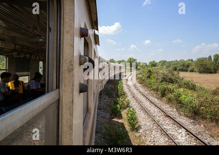 Nur wenige Menschen auf dem alten S-Bahn auf der Yangon kreisförmigen Bahn am Stadtrand von Yangon, Myanmar (Burma) an einem sonnigen Tag. Stockfoto