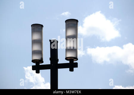 Die zwei lampenschirmen eines modernen Straßenlaterne vor einem blauen Himmel mit Wolken. Stockfoto