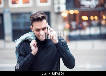 Junger stattlicher Mann mit seinem Handy, genießen Sie einen Tag auf der Straße Stockfoto