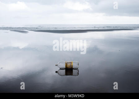 Eine leere Plastikflasche mit Wasser an einem Strand in Choco, Kolumbien wider Stockfoto