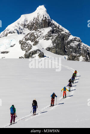 Skitourengeher roped gemeinsam für Sicherheit von gletscherspalten verwenden synthetische Felle auf Skiern den Berg hinauf zu klettern; RongÃ © Insel; Arctowski Halbinsel; Antarktis Stockfoto