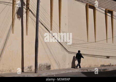 Ein fussgänger vor einem gelben Wand auf der Straße in Sucre, Bolivien Stockfoto