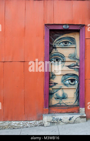 Menschliche Gesichter an die Tür eines bunten Haus aus Wellblech in Valparaiso, Chile, lackiert Stockfoto