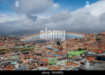 Ein Regenbogen hängen in den blauen Himmel über einem Elendsviertel im Süden von Bogotá, Kolumbien Stockfoto