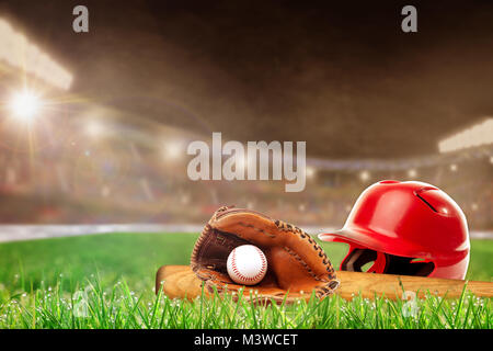 Baseball Helm, bat, Handschuh und Ball auf Gras in Hell im Stadion mit Fokus auf Vorder- und flache Tiefenschärfe auf Hintergrund beleuchtet. Delib Stockfoto