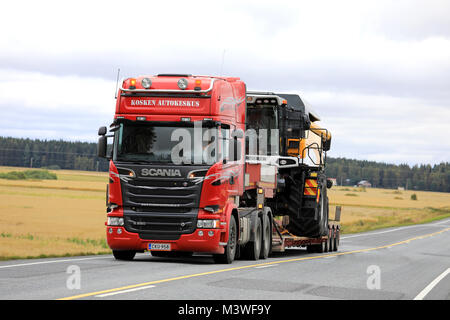 KOSKI TL, Finnland - 15. SEPTEMBER 2017: Rote Scania R580 semi Trailer von Kosken Autokeskus Transporte Sampo Rosenlew Mähdrescher als große Last entlang der Autobahn Stockfoto