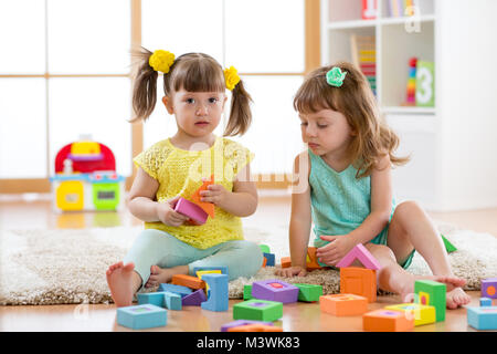 Kinder spielen mit Entwicklungsstörungen Spielzeug daheim oder Kindergarten oder Kinderkrippe Stockfoto