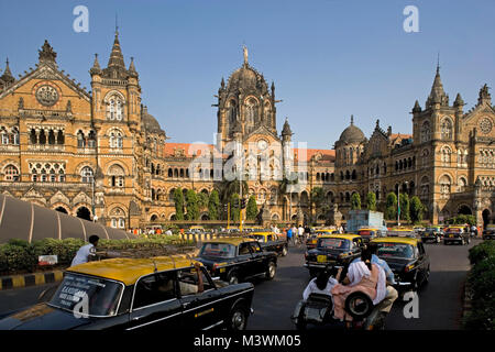 Indien, Mumbai, Chatrapati Shivaji Terminus (ehemalige Victoria Terminus), im gotischen Stil erbaut. Verkehr in stark befahrenen Straße. UNESCO-Weltkulturerbe. Stockfoto