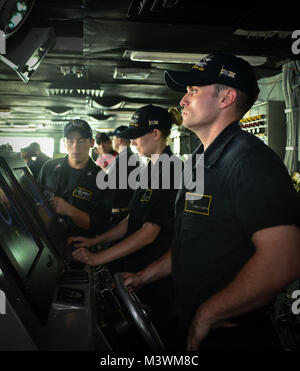 Straße von Hormuz (23. Juli 2017) der US-Marine Operations Specialist Seaman James Connor Garvey (rechts), von St. Charles, Illinois und der bootsmann Mate Seemann Marisa Dimaria, von Beaver Falls, Pa, dem Flugzeugträger USS Nimitz (CVN 68), 23. Juli 2017, in der Straße von Hormus zu steuern. Der Nimitz ist in den USA der 5. Flotte Bereich der Operationen zur Unterstützung der Operation inhärenten Lösung bereitgestellt. Während in dieser Region, das Schiff und Streik Gruppe leiten Maritime Security Operations Verbündeten und Partnern zu beruhigen, die Freiheit der Schifffahrt zu bewahren und den freien Fluss des Handels halten. (U.S. Marine Foto von Stockfoto