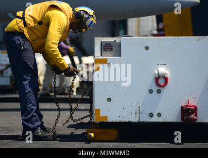 Arabischen Golf (31. Juli 2017) der US-Marine in der Luftfahrt Bootsmann Mate (Handling) 3. Klasse Robert White, von Atlanta, Ketten, einem Traktor an Bord der Flugzeugträger USS Nimitz (CVN 68), 31. Juli 2017, in den Persischen Golf. Der Nimitz ist in den USA der 5. Flotte Bereich der Operationen zur Unterstützung der Operation inhärenten Lösung bereitgestellt. Während in dieser Region, das Schiff und Streik Gruppe leiten Maritime Security Operations Verbündeten und Partnern zu beruhigen, die Freiheit der Schifffahrt zu bewahren und den freien Fluss des Handels halten. (U.S. Marine Foto von Mass Communication Specialist 3. Klasse Ian Kinkead) 170731 - Stockfoto