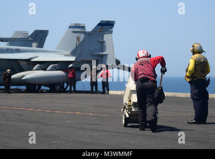 Arabischen Golf (31. Juli 2017) U.S. Navy Aviation Ordnanceman 3. Klasse Tanisha Stewart, von Stockton, Kalifornien, bewegt sich Munition auf dem Flugdeck der Flugzeugträger USS Nimitz (CVN 68), während andere Segler Flugbetrieb durchzuführen, 31. Juli 2017, in den Persischen Golf. Der Nimitz ist in den USA der 5. Flotte Bereich der Operationen zur Unterstützung der Operation inhärenten Lösung bereitgestellt. Während in dieser Region, das Schiff und Streik Gruppe leiten Maritime Security Operations Verbündeten und Partnern zu beruhigen, die Freiheit der Schifffahrt zu bewahren und den freien Fluss des Handels halten. (U.S. Marine Foto von Masse Co Stockfoto