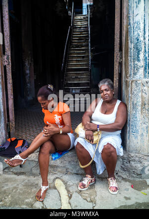 Zwei kubanischen Frauen sitzen auf dem Stoop einer Tür in Havanna, Kuba Stockfoto