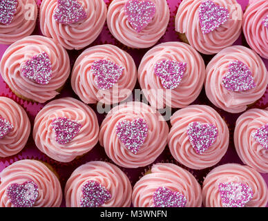 Bunte rosa Herzen Cupcakes auf einem rosa Hintergrund. Muster Stockfoto