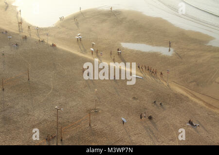 Die Menschen beginnen, ein Winter Tel Aviv Strand bei Sonnenuntergang zu verlassen. Stockfoto