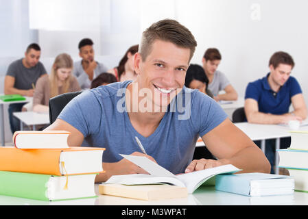 Portrait eines glücklichen männlichen Schüler im Klassenzimmer sitzen Stockfoto