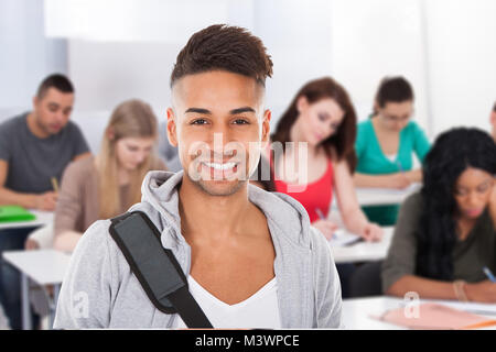 Porträt eines lächelnden Männliche Schüler im Klassenzimmer stehen Stockfoto