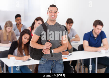 Porträt eines lächelnden Männliche Schüler im Klassenzimmer stehen Stockfoto