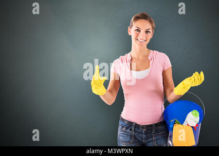 Portrait einer weiblichen Hausmeister mit der Reinigung der Geräte Gestik Daumen hoch Stockfoto