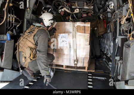 170925-N-SZ 865-103 SAN JUAN, Puerto Rico (Sept. 25, 2017) Marines an der 26 Marine Expeditionary Unit (26 MEU), an Bord der Amphibisches Schiff USS Kearsarge (LHD 3), Last militärischen Bereich Rationen, bekannt als MRE oder Mahlzeiten, bereit zu essen, auf eine MV-22 Osprey an Luis Munoz Marin International Airport in San Juan, Puerto Rico. Kearsarge und der 26 MEU unterstützen mit Hilfsmaßnahmen in den Wirbelsturm Maria. Das Verteidigungsministerium ist die Unterstützung der Federal Emergency Management Agency, die federführende Bundesbehörde, dabei helfen, die Betroffenen durch den Hurrikan Maria Stockfoto