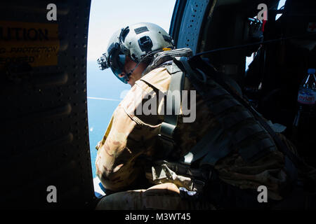 Us-Armee Sgt. Zachary J. Champagner, ein Hubschrauber Crew Chief mit Joint Task Force - Leeward Inseln, Kollegen aus dem Fenster eines UH-60 Black Hawk Hubschrauber, als es über das Karibische Meer auf den Hafen von Roseau, Dominica fliegen, Wasser, Menschen durch den Hurrikan Maria, 01.10.2017, betroffen zu liefern. Auf Antrag der US-Agentur für Internationale Entwicklung, JTF-LI bereitgestellt hat, Flugzeuge und Service Mitglieder in der Bereitstellung von Hilfsgütern zu Dominica in der Nachmahd des Hurrikans Maria zu unterstützen. Die Task Force ist in den USA eine militärische Einheit, die aus Marinen, Soldaten, Matrosen und Fliegern und Re Stockfoto