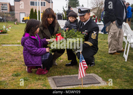 171216-N-VH 385-0095 Bremerton, Washington (31. 16, 2017) Chef der Luftfahrt Bootsmann Mate (Handling) Maungwai Soe, ein Eingeborener von Rochester, New York, und Naval Base Kitsap zugeordnet, und seine Familie legen einen Kranz auf dem Grab von einem gefallenen service Mitglied während der 6. jährlichen Feier Ivy Green's Friedhof Kränze über Amerika. Kränze über Amerika jährlich bietet Kränze an Ehre gefallenen Service Mitglieder während der Ferienzeit erinnern und. (U.S. Marine Foto von Mass Communication Specialist 2. Klasse Wyatt L. Anthony/Freigegeben) 171216-N-VH 385-0095 von Naval Base Kitsap (NBK) Stockfoto