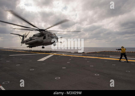 180130-N-NB 544-175 philippinischen Meer (Jan. 30, 2018) der Luftfahrt Bootsmann Mate (Handling) 3. Klasse Tiffanie Allenderriley, Signale der Pilot einer CH-53E Super Stallion Hubschrauber zum "WOLFPACK" von schweren Marine Helicopter Squadron (HMH) 466 zugeordnet, es landet auf dem Flugdeck des Amphibious Assault ship USS BONHOMME RICHARD (LHD6). Bonhomme Richard ist in den Indo-Asia-Pazifik-Region als Teil einer regelmäßigen Patrouillen- und bietet eine schnelle Reaktionsfähigkeit im Falle eines regionalen Kontingenz oder Naturkatastrophen. (U.S. Marine Foto von Mass Communication Specialist 2. Stockfoto