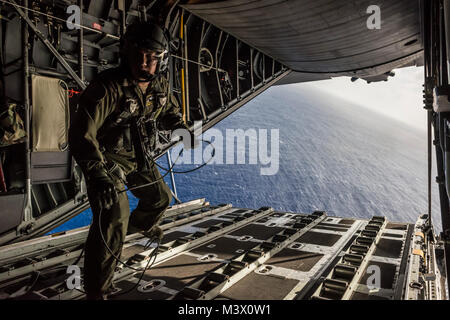 Us Air Force Chief Master Sgt. Reynold Albright, ein lademeister mit der 36Th Airlift Squadron bei Yokota Air Base, Japan, Wanderungen von der Rampe aus einer C-130 Hercules Flugzeuge nach dem Bündel der humanitären Hilfe Elemente über eine Insel im Pazifischen Ozean 15.12.2012, während des Betriebs Weihnachten Fallen. Weihnachten Drop ist ein jährlicher Aufwand von Flieger an Yokota und Andersen Air Force Base, Guam, waren mehr als 30.000 Inselbewohner in den Föderierten Staaten von Mikronesien, die Marshall-Inseln und das Commonwealth der Nördlichen Marianen gespendet zu liefern. Während der acht Tage 2012 Veranstaltung, Airm Stockfoto