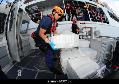 Mitglieder der Besatzung an Bord der Coast Guard Cutter Valiant transfer Ballen von Schmuggelware zu einem Coast Guard Station Miami 45-Fuß-Antwort Boot - Medium Crew während einer am Meer Transfer 19.02.2013. Insgesamt wird das Verbot verhindert 935 Pfund Kokain Großhandel mit einem geschätzten Wert von mehr als $ 11 Millionen vom Bilden es in die Vereinigten Staaten. U.S. Coast Guard Foto von Petty Officer 3. Klasse Jon-Paul Rios. 130219-G-KZ 985-023 durch ussouthcom Stockfoto