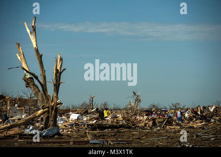 Bewohner in der Moore, Okla. Suche durch die Trümmer, wo ihre Häuser stand einst auf der Suche nach Salvageable Einträge Mai 22, 2013. Am Montag ein EF-5 Tornado, mit Winden von mindestens 200 km/h, für 20 Meilen, so dass eine zwei Kilometer breite Schneise der Verwüstung, Nivellierung Wohnungen, zerkleinern Fahrzeuge, und tötet mehr als 20 Menschen. Mehr als 115 Oklahoma National Guard aktiviert wurden in der Rettungs- und Hilfsmaßnahmen zu unterstützen. (U.S. Air Force Foto: Staff Sgt. Jonathan Snyder/Freigegeben) 130522-F-RH 756-010 durch AirmanMagazine Stockfoto