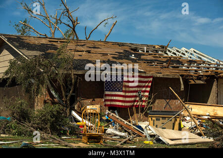 In der Moore Bewohner, Okla. zeigt eine amerikanische Flagge auf Ihrem home Mai 22, 2013. Am Montag ein EF-5 Tornado, mit Winden von mindestens 200 km/h, für 20 Meilen, so dass eine zwei Kilometer breite Schneise der Verwüstung, Nivellierung Wohnungen, zerkleinern Fahrzeuge, und tötet mehr als 20 Menschen. Mehr als 115 Oklahoma National Guard aktiviert wurden in der Rettungs- und Hilfsmaßnahmen zu unterstützen. (U.S. Air Force Foto: Staff Sgt. Jonathan Snyder/Freigegeben) 130522-F-RH 756-056 durch AirmanMagazine Stockfoto