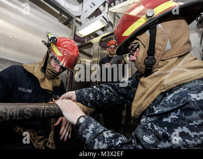 Golf von Oman (12. Juli 2013) - Segler simulieren das Patchen eines Leitung während eines General Quarters bohren an Bord der Flugzeugträger USS Nimitz (CVN 68). Der Nimitz Strike Group ist in die USA 5 Flotte Verantwortungsbereich Durchführung Maritime Security Operations eingesetzt, Theater Sicherheit Bemühungen um Zusammenarbeit und Unterstützung für die Operation Enduring Freedom. (U.S. Marine Foto von Mass Communication Specialist Seaman Apprentice Aiyana Österlichen/Freigegeben) vom 12. Juli Batch 15 der 16 von USS NIMITZ (CVN 68) Stockfoto