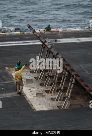 Golf von Oman (Juli 15, 2013) Segler prüfen ein Jet blast Abweiser auf dem Flight Deck des Flugzeugträgers USS Nimitz (CVN 68). Der Nimitz Strike Group ist in die USA 5 Flotte Verantwortungsbereich Durchführung Maritime Security Operations eingesetzt, Theater Sicherheit Bemühungen um Zusammenarbeit und Unterstützung für die Operation Enduring Freedom. (U.S. Marine Foto von Mass Communication Specialist 3. Klasse Raul Moreno jr./Freigegeben) vom 15. Juli Batch 19 der 31 von USS NIMITZ (CVN 68) Stockfoto