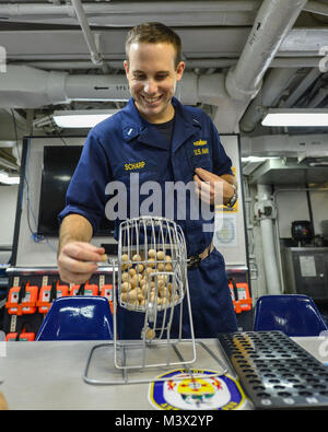 ARABIAN GULF (Aug. 16, 2013) Lt. j.g. Brian Scharp Spins ein Bingo Rad auf das Chaos Decks an Bord der geführte-missile Cruiser USS Monterey (CG61) während ein Bingo Abend. Monterey ist zur Unterstützung der Maritime Security Operations und Theater Sicherheit Zusammenarbeit in den USA 5 Flotte Verantwortungsbereich eingesetzt. (U.S. Marine Foto von Mass Communication Specialist 3. Klasse Billy Ho/Freigegeben) 23. August Batch 1 von 12 von USS NIMITZ (CVN 68) Stockfoto