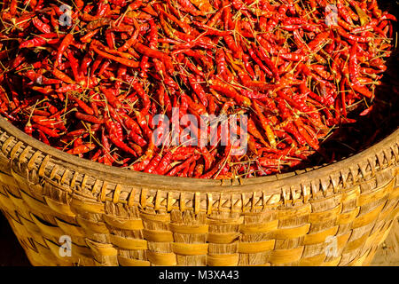 Chili, in Bambuskörben verpackt, ist für den Verkauf auf dem Gemüsemarkt in den Straßen der Stadt Stockfoto