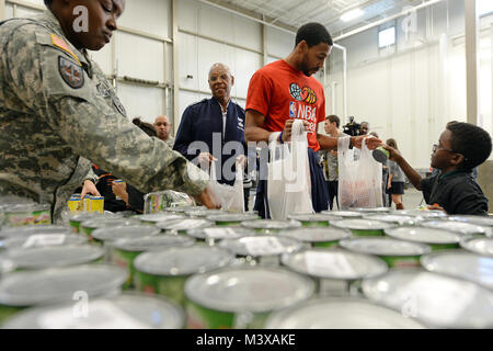 Washington Wizards guard Garrett Tempel und Allgemeine Larry Spencer, Luftwaffe stellvertretender Stabschef, halten essen Montage Taschen während eines freiwilligen Bemühung an der Capital Area Food Bank in Washington, D.C., Okt. 24, 2014. Der Abteilung für die Verteidigung und die National Basketball Association haben sich zu einer Initiative mit dem Namen "Service" eine Kultur der Service- und ehrenamtliche Tätigkeiten in den Gemeinschaften, in denen Service Mitglieder leben und arbeiten zu schaffen. (DoD Nachrichten Foto durch EJ Hersom) 141024 - D-DB 155-005 von DoD News Fotos Stockfoto